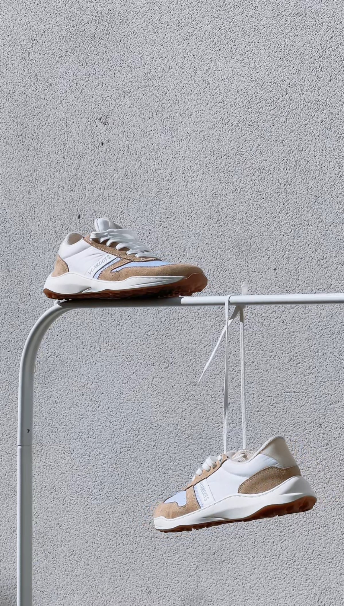 Zapatillas VoaRoots colgando al aire libre sobre fondo gris, calzado barefoot moderno y estético